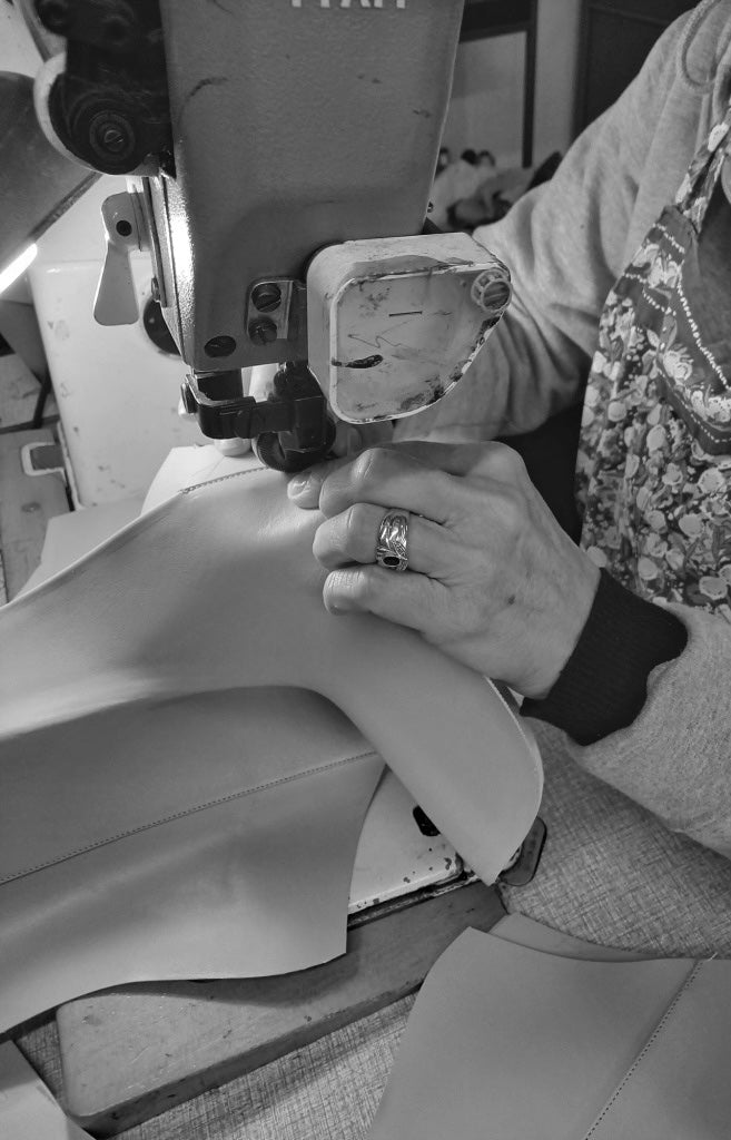 En av våra hantverkare syr den beiga skinnstövletten INGA på maskin. I Civitanova Marche Italien.