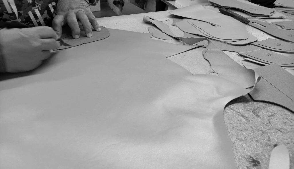 Vår beiga skinnstövletts mönster skärs ut för hand på nappaskinnet hos vår fabrik och leverantör i Marche Italien.