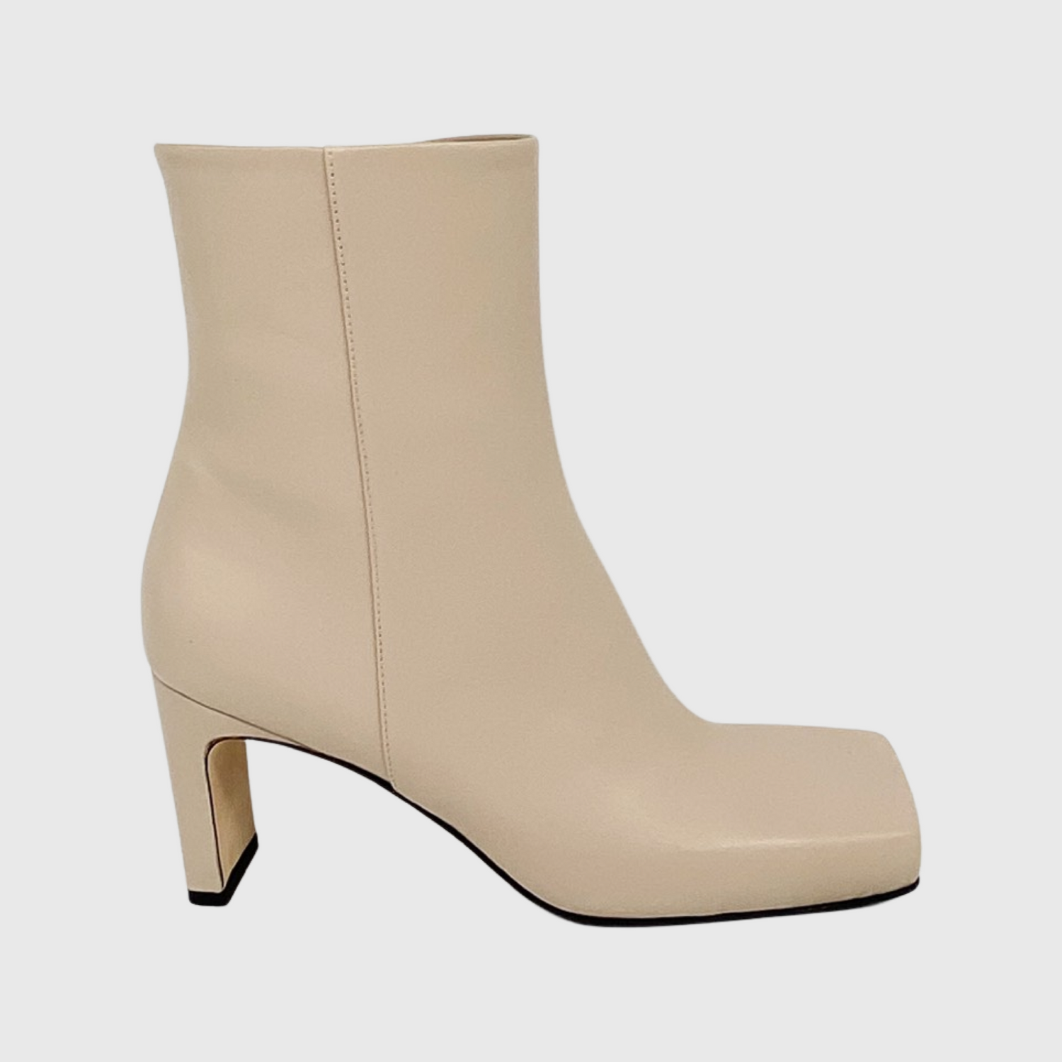 Hållbara beiga skinnstövletter i mjukt nappaskinn med fyrkantig tå och small men bred klack. Kantig tå med en lyxig design och känsla. Vårens och sommarens cremiga heta ljusa beiga färg. Stövletten från sidan och skymtar vero cuoio sulan under skon, handgjorda i Marche Italien.