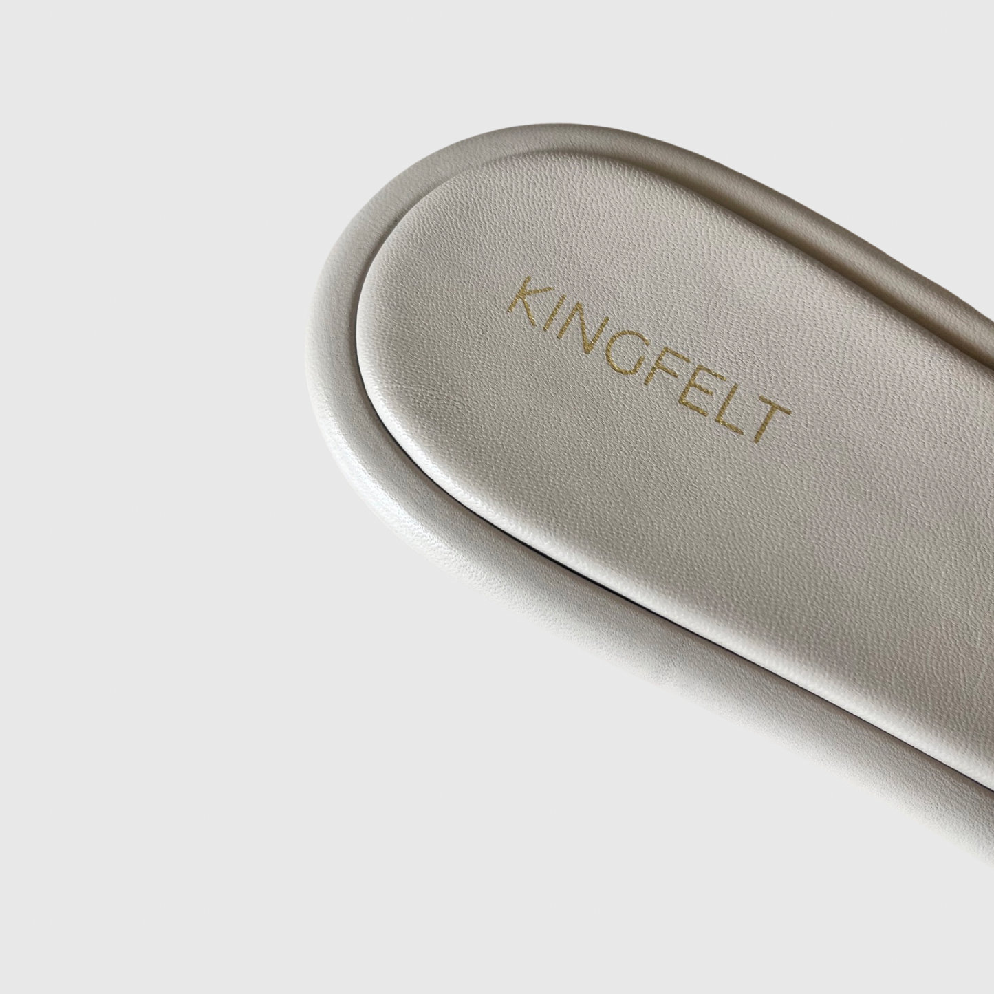 Skinnsandal i nappaskinn. Detalj bild på hälen. Mjukt och följsamt skinn för bästa komfort. Detalj Kingfelt footwears logga i guld visas på hälen. Handgjorda i Italien.