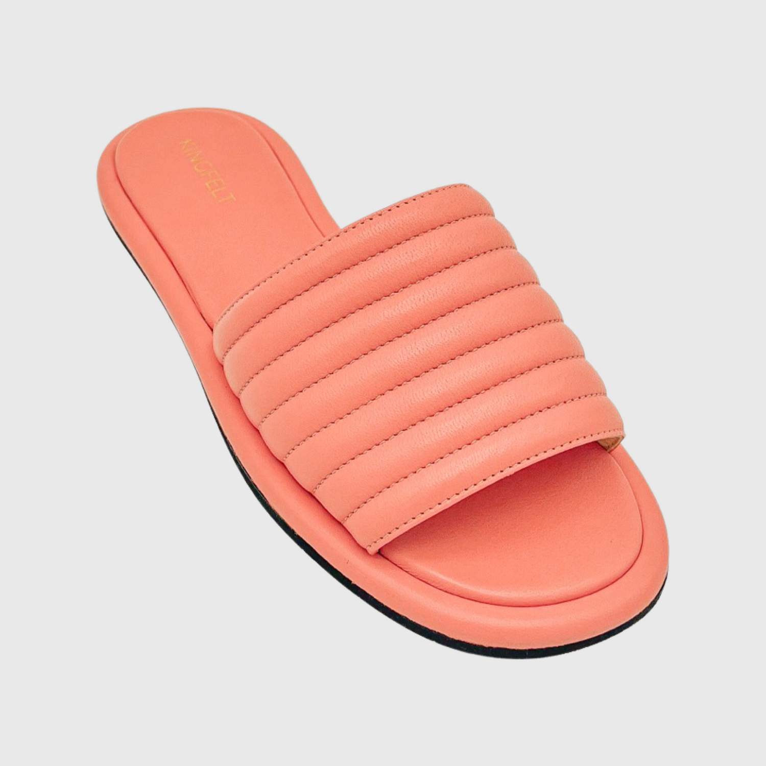Skinnsandale med öppen tå i korallrosa nappaskinn. Ovanifrån med en veckad ovandel med sömmar om 1 cm. Guldloga i KINGFELT på hälen. Svart sula under. 